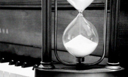 hourglass on piano keyboard black and white