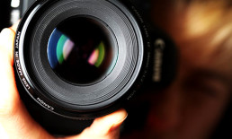 Close-up of camera lens in photographer's hands