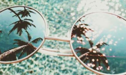 The Best Advice So Far: The 20-Minute Vacation - sunglasses reflecting palm trees over tropical waters